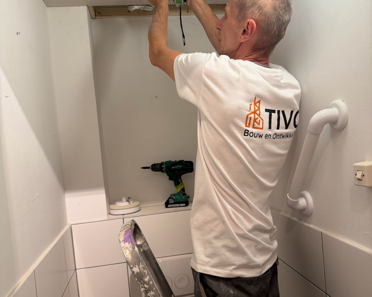Plafondluik en ventilatiekanaal in een toilet, tijdens onderhoudswerk