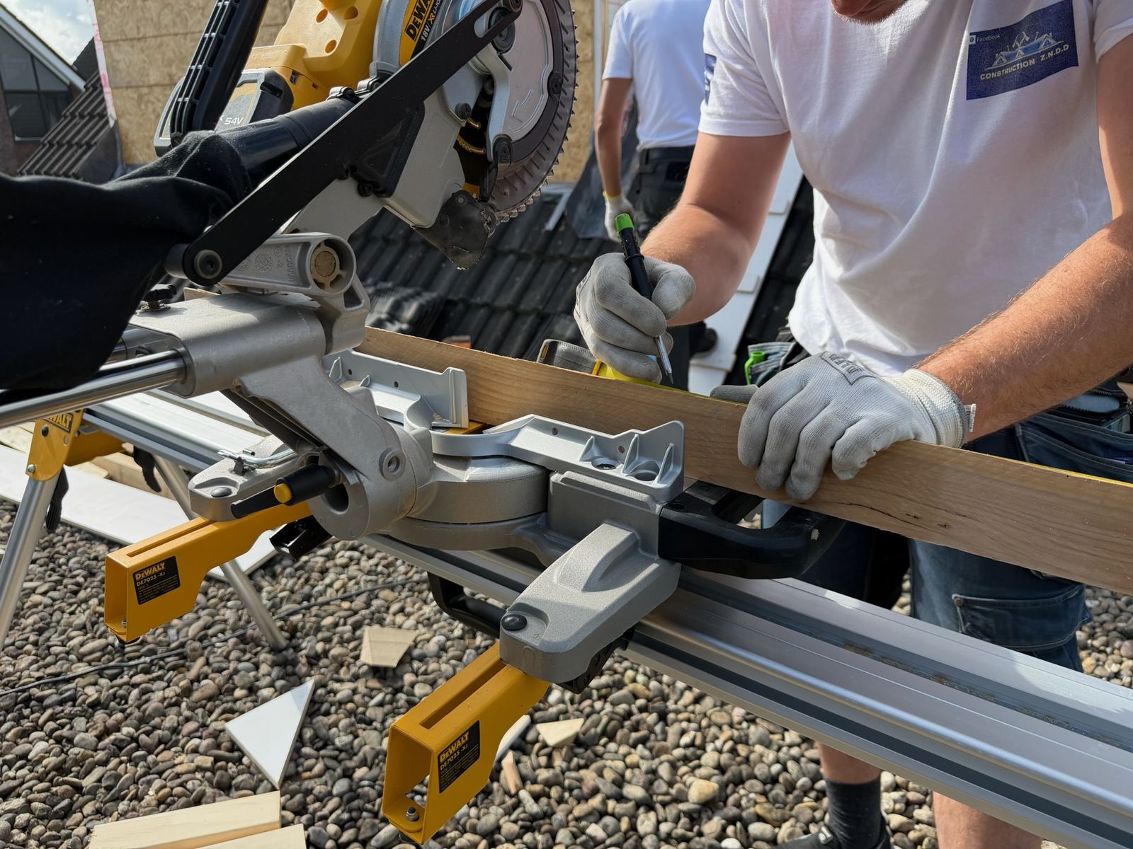 Hout op maat gezaagd op een werkbank naast de uitbouw in aanbouw